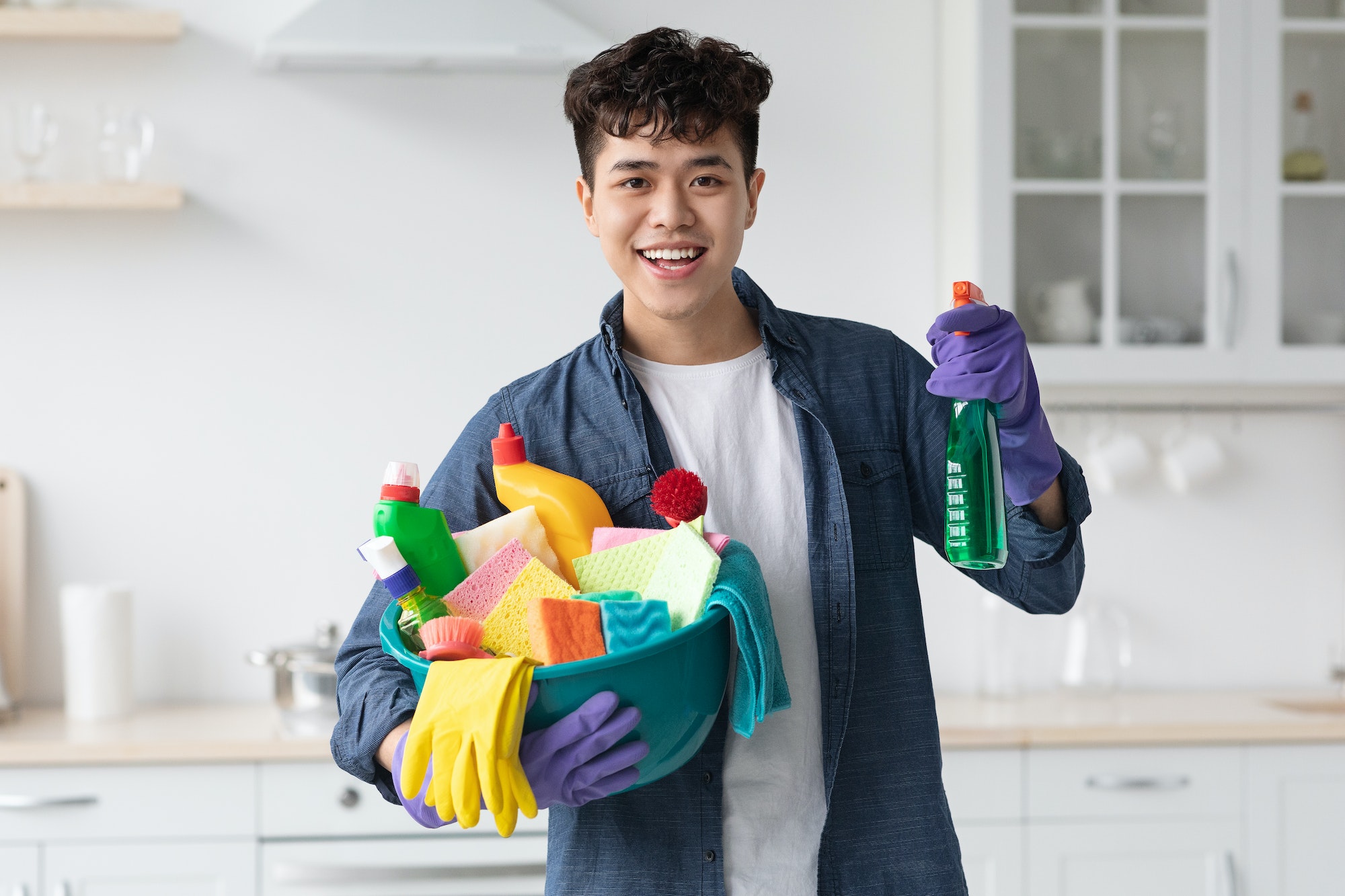 Smiling asian guy ready for cleaning apartment